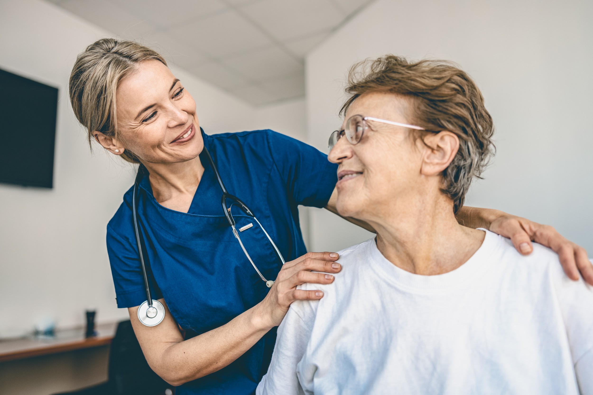 Arzt assistiert älterem Patienten.